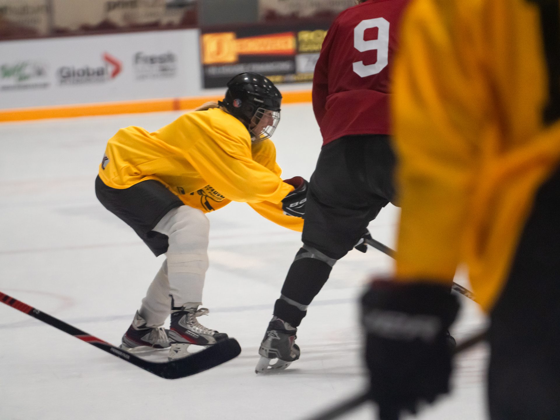 Players battling for the puck in front of the net during a Canadian Beer League game